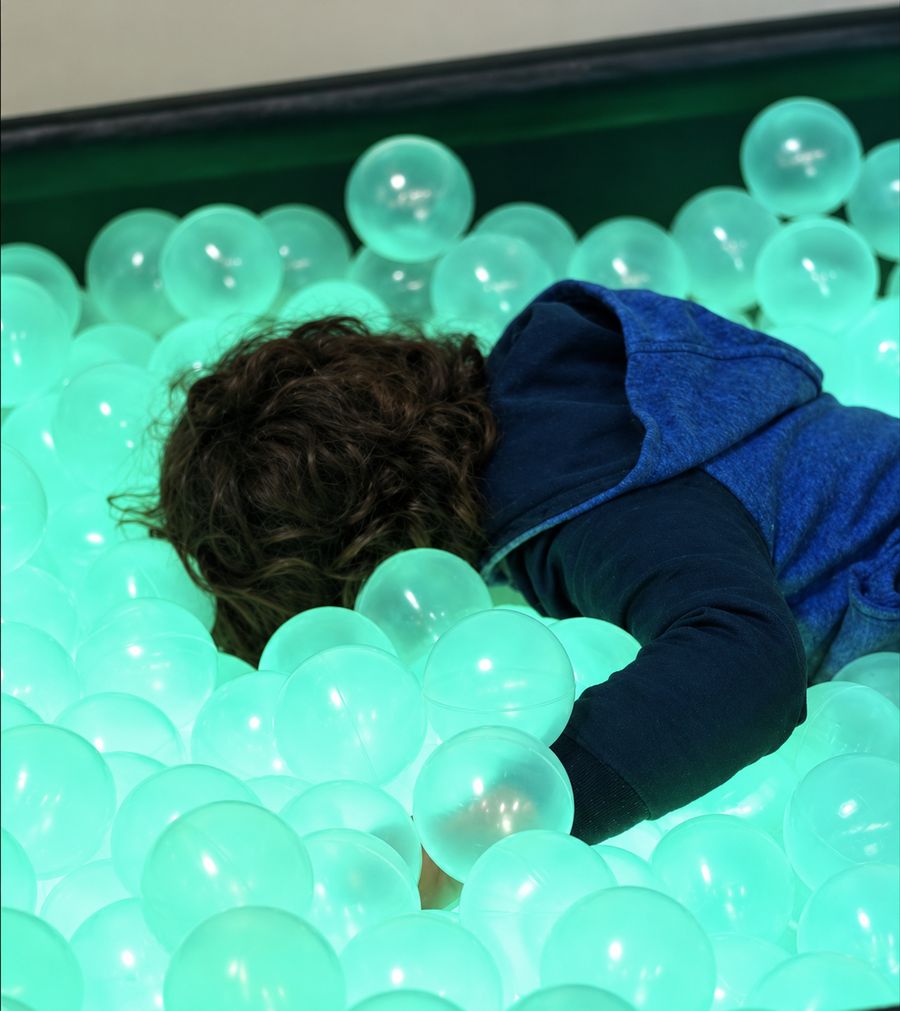 Criança na piscina de bolinhas iluminada